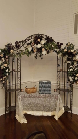 Arch with draped flowers and table